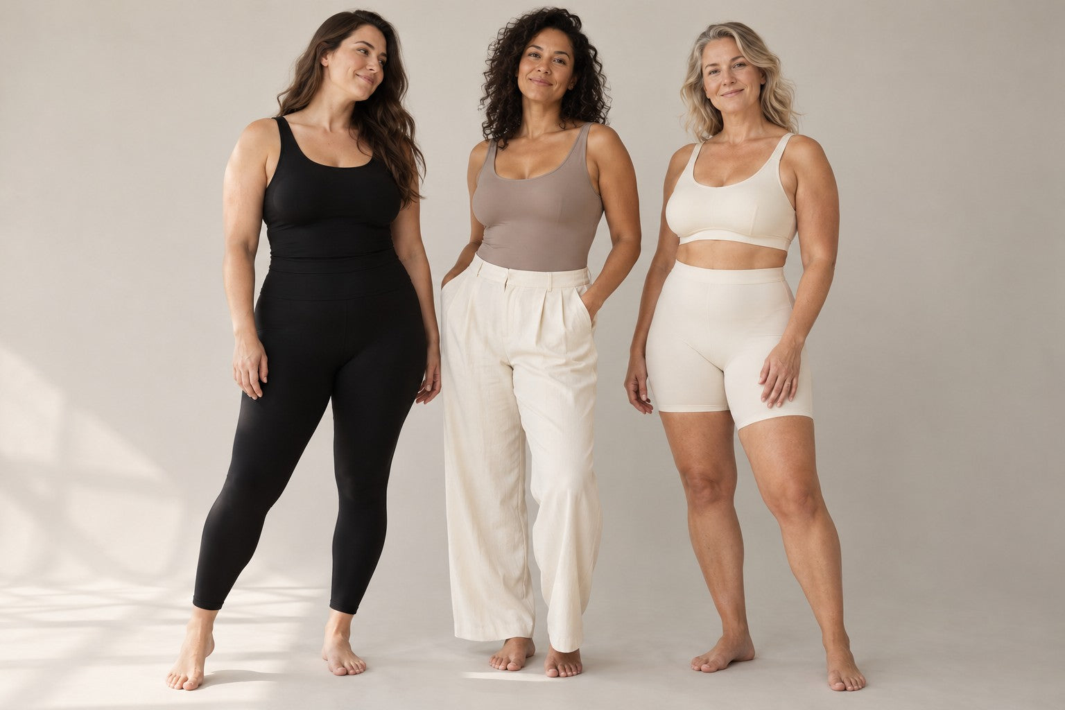 Three adult women wearing black, taupe and cream everyday base layers
